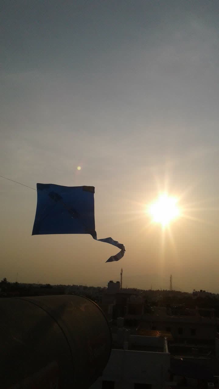 A paper kite flying against the evening sun