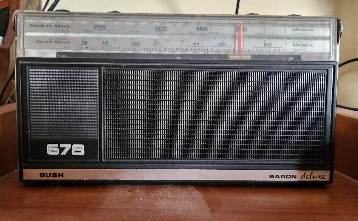 An old analogue radio with a tuning dial and speaker grille